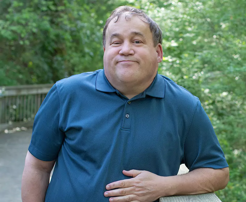 Man outside leaning on a banister